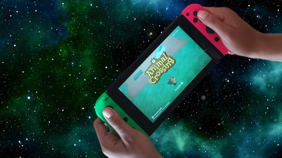 Nintendo Switch, auf dem Bildschirm ist das Spiel "Animal Crossing" zu sehen, Sternenhimmel im Hintergrund