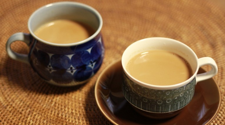 Chai Tee in zwei kleinen Kaffeetassen mit Untersetzer