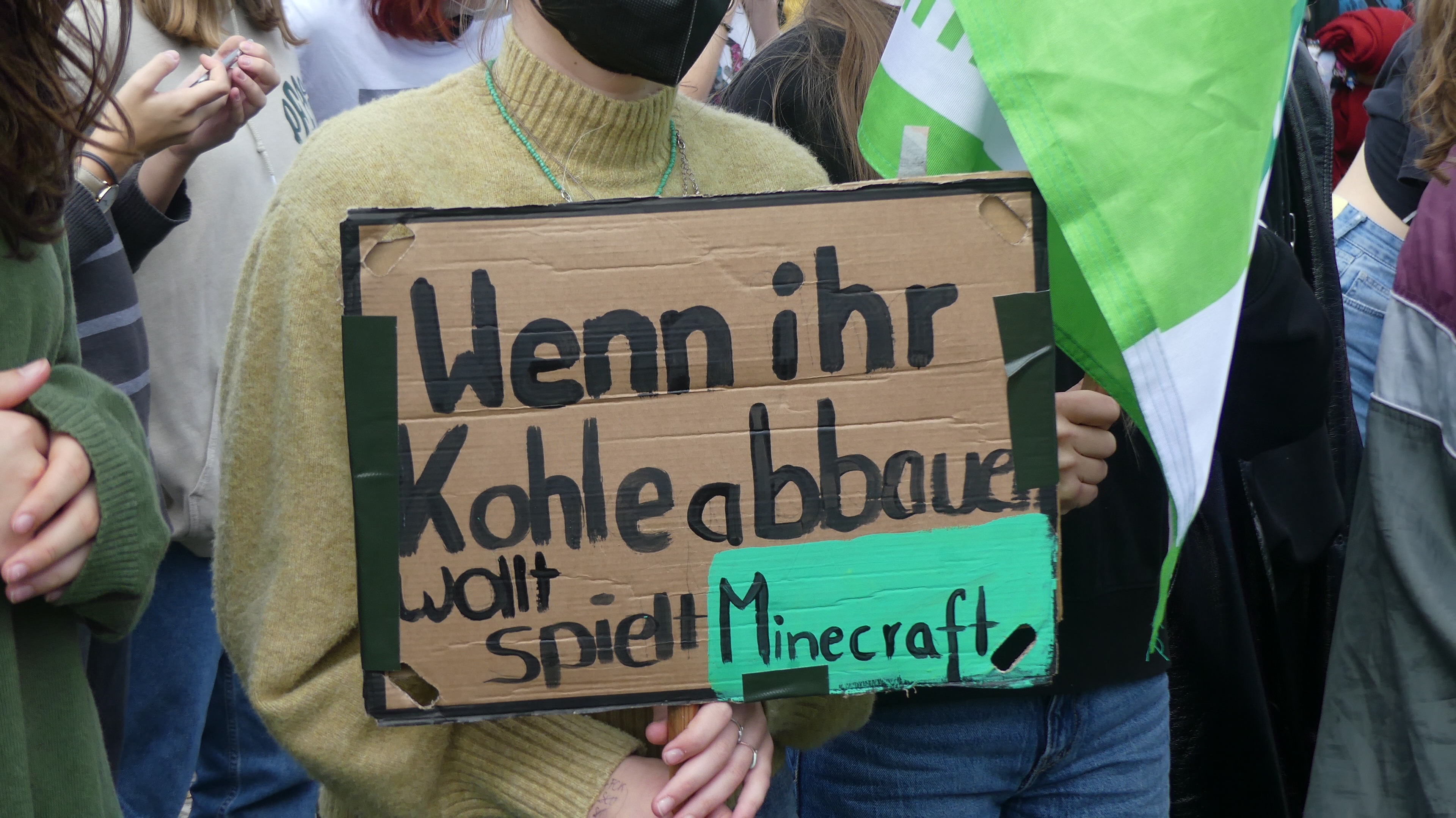 Ein Demonstrationsschild auf dem "Wenn ihr Kohle abbauen wollt, spielt Minecraft" steht