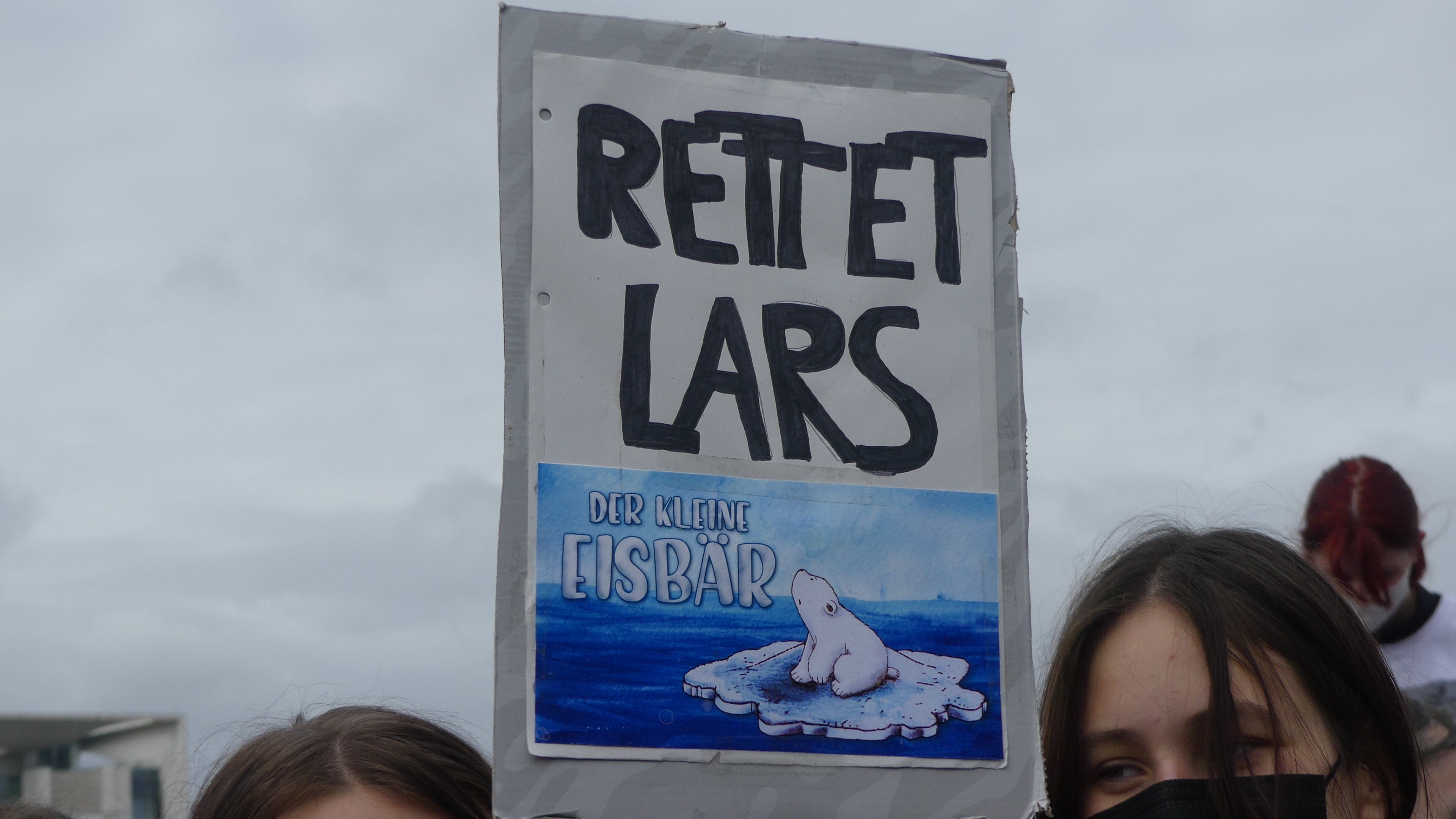 Ein Demonstrationsschild auf dem "Rettet Lars den kleinen Eisbär" steht 