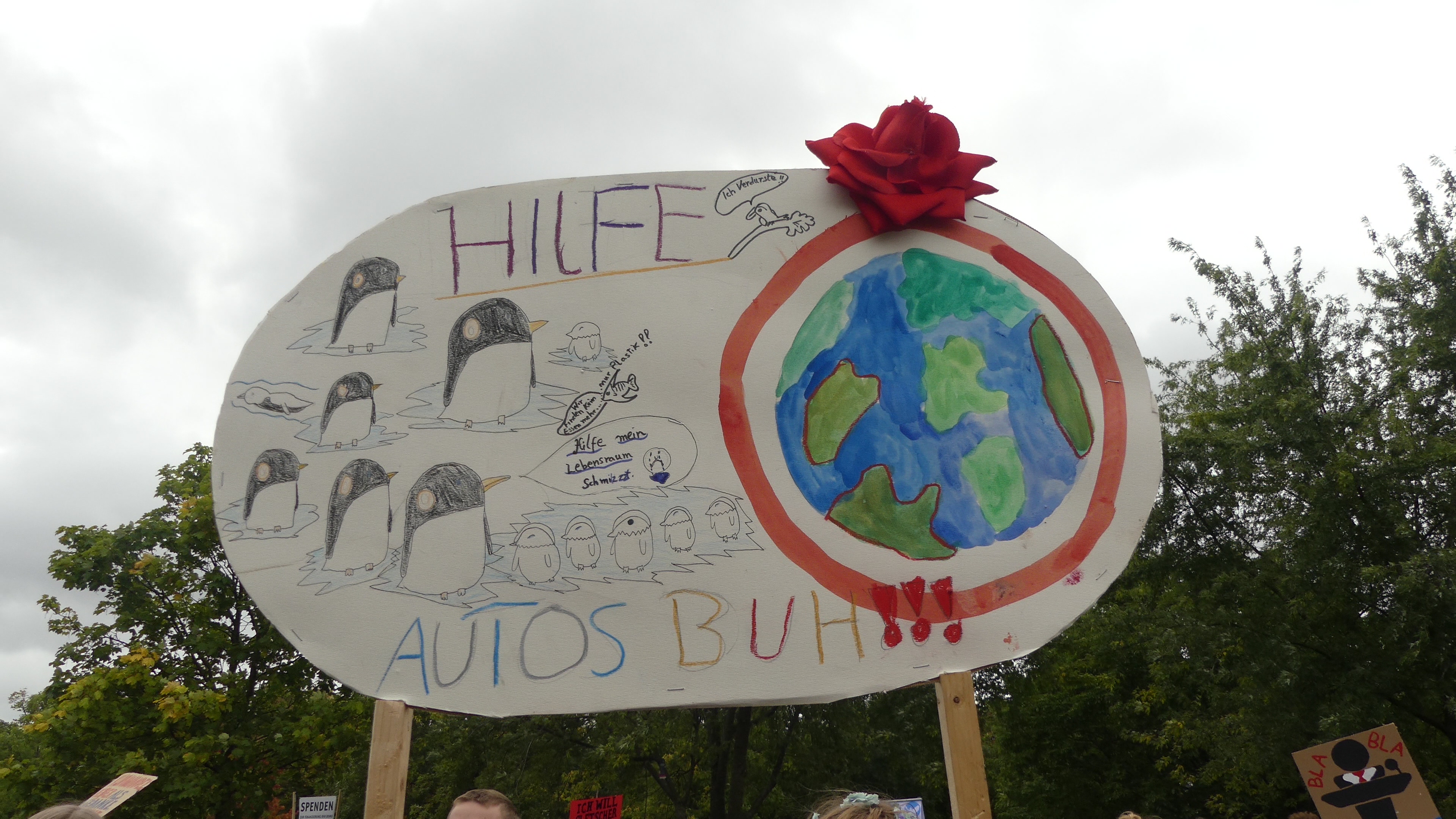 Demoplakat: Pinguine fliehen vor Autos