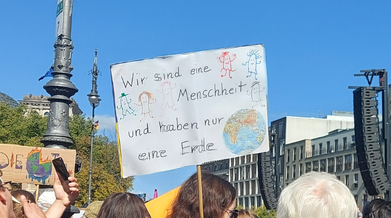 Plakat mit gemalter Erde und Menschen