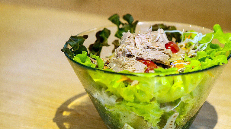 Frischer Salat in einer großen Glasschüssel mit Thunfisch, Tomate und Kopfsalat