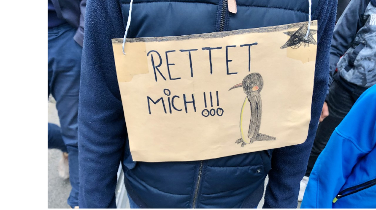 selbstgebasteltes Demoplakat mit Pinguin und der Aufschrift Rettet mich!