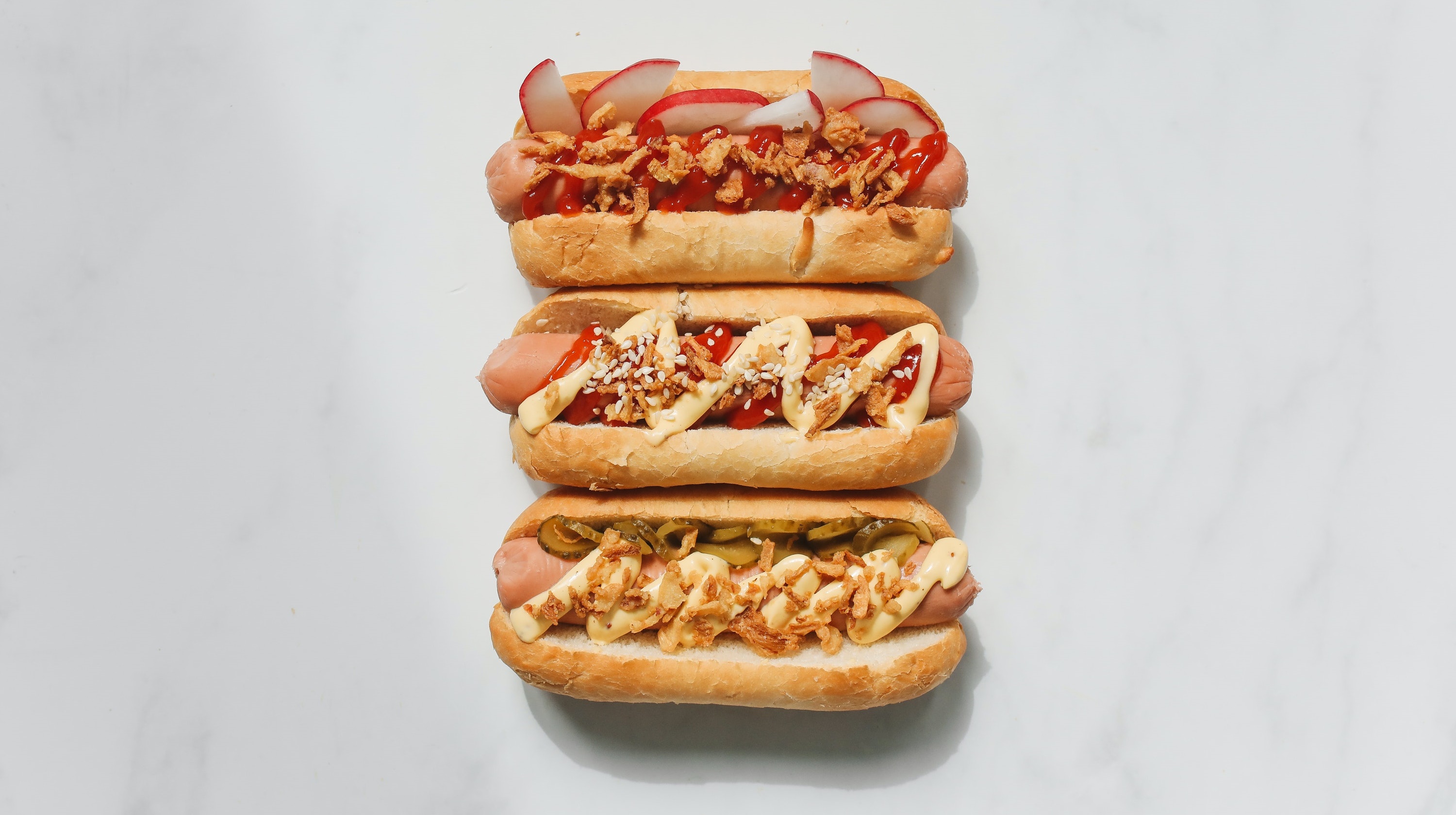 Drei unterschiedlich belegte Hot Dogs