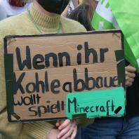 Ein Demonstrationsschild auf dem "Wenn ihr Kohle abbauen wollt, spielt Minecraft" steht