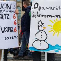 Zwei Demoplakate mit Zeugnis für die Klimapolitik und der Frage, was ein Schneemann ist
