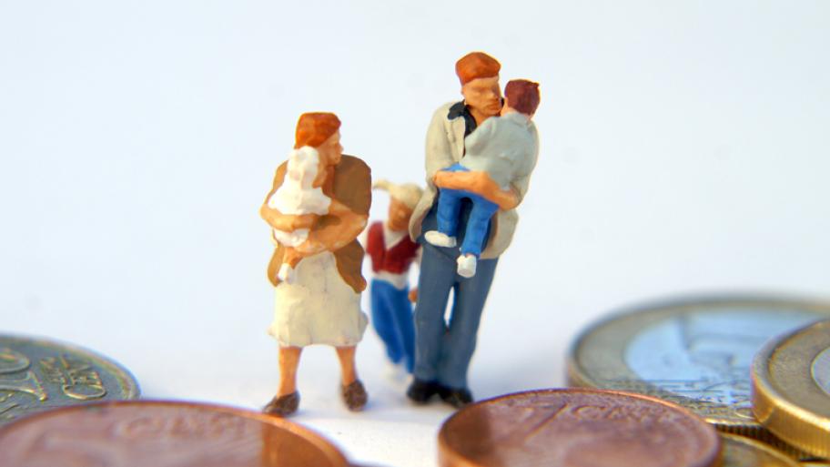 Kleine Figuren einer Familie, davor liegt Kleingeld