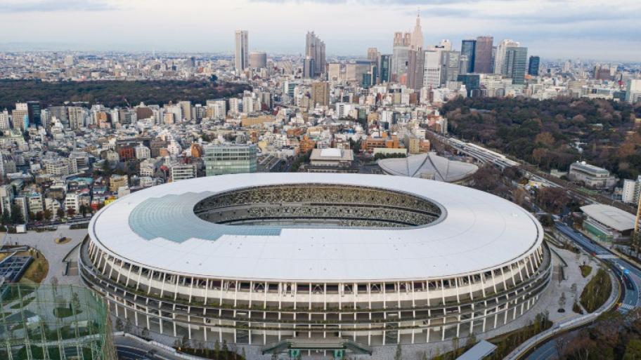 im Vordergrund das Nationalstadion in Tokio, im Hintergrund Stadtansicht mit Hochhäusern