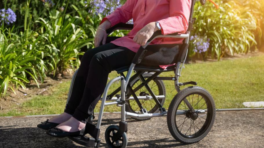 eine ältere Frau sitzt im Rollstuhl