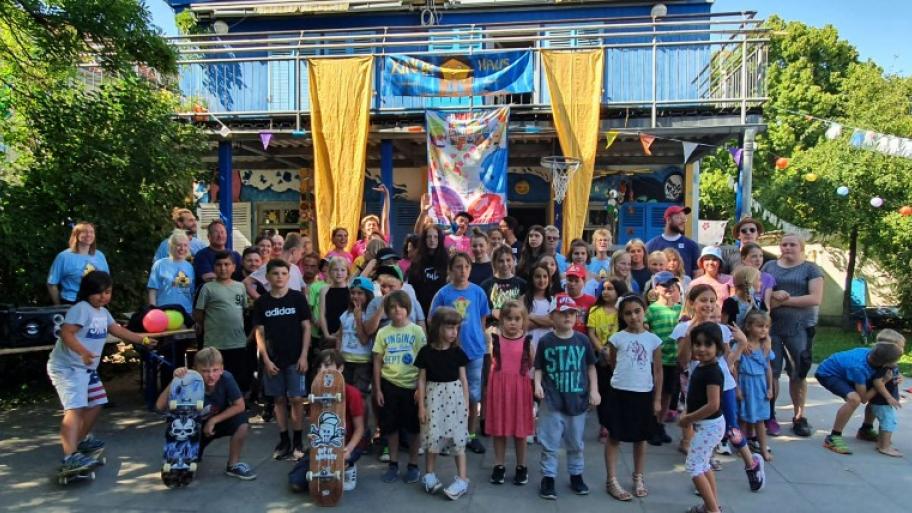 eine große Gruppe Kinder und Erzieher:innen steht vor dem Kinderhaus Weimar, alle sehr fröhlich
