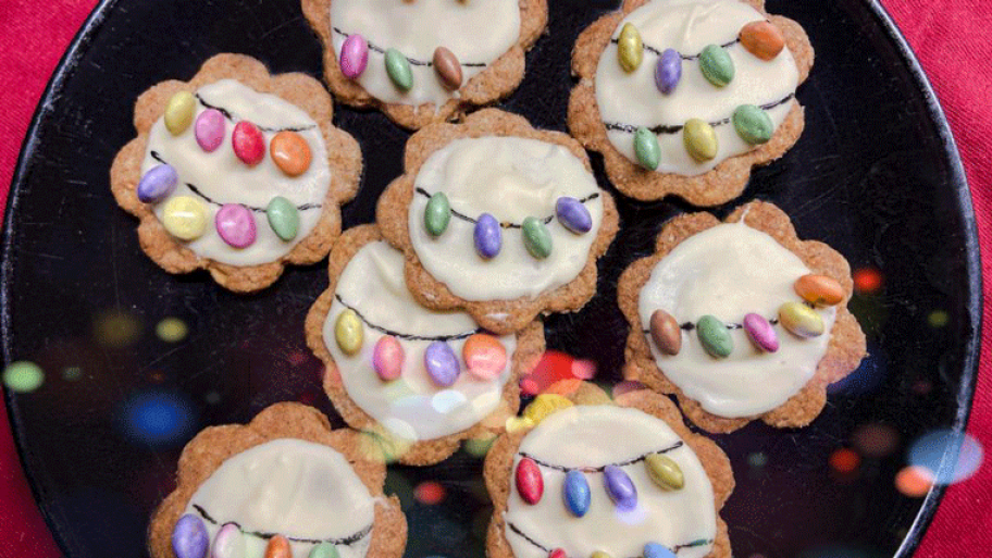 Plätzchen mit Zuckerguss und Smarties raufgeklebt liegen auf einem Teller