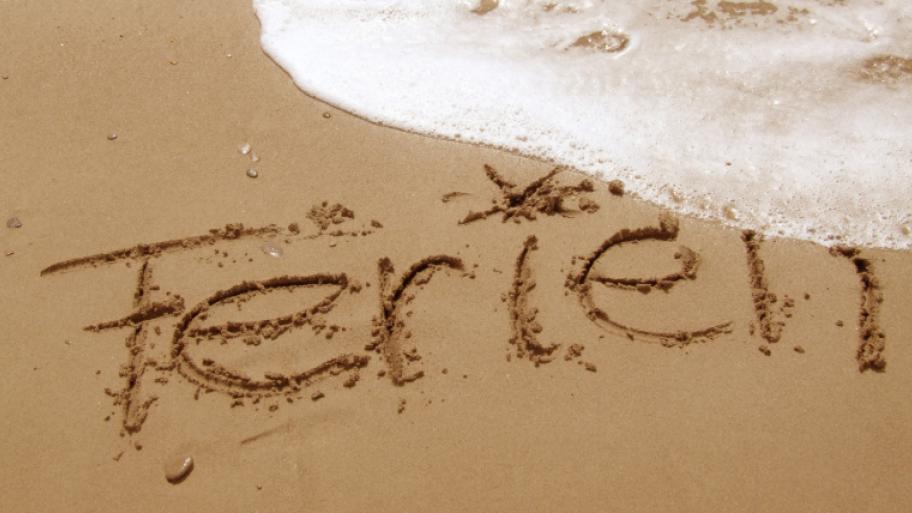 Das Wort Ferien in den Sand geschrieben