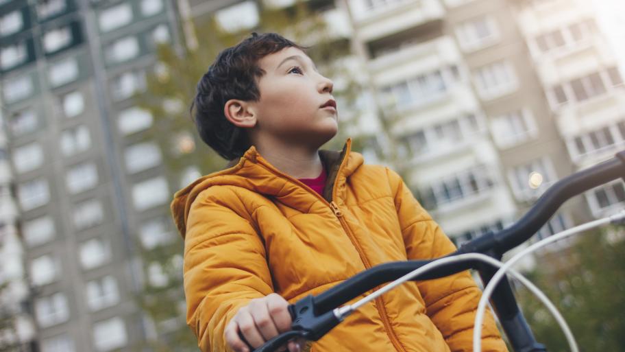 Kind mit Fahrrad in der Stadt