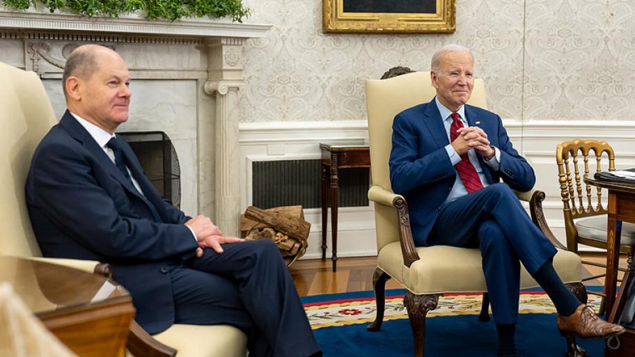 zwei Männer im Anzug sitzen im Sessel und schauen in die Kamera 