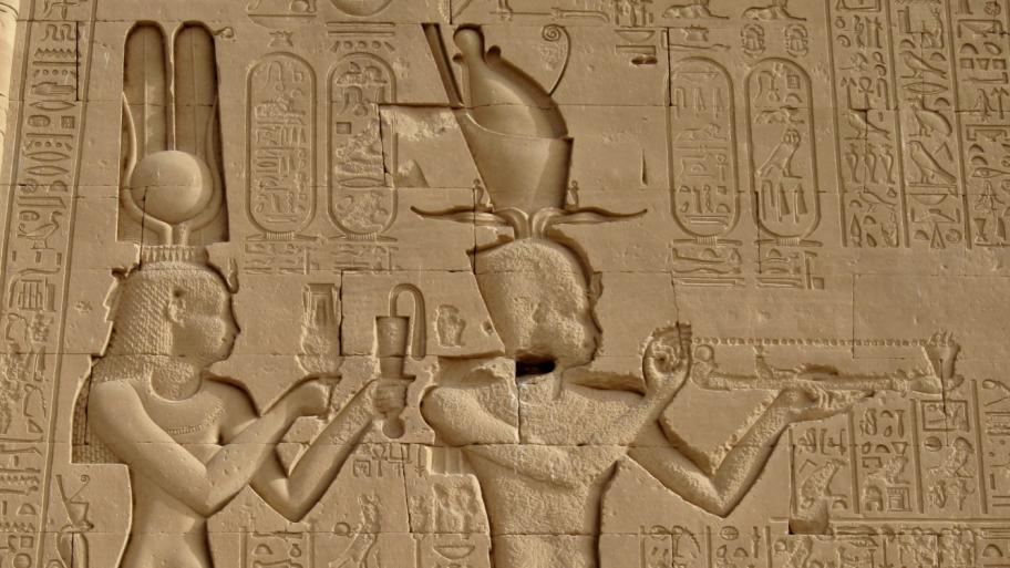 Detailansicht eines altägyptischen Reliefs ins Stein gemeißelt mit Figuren und Hieroglyphen