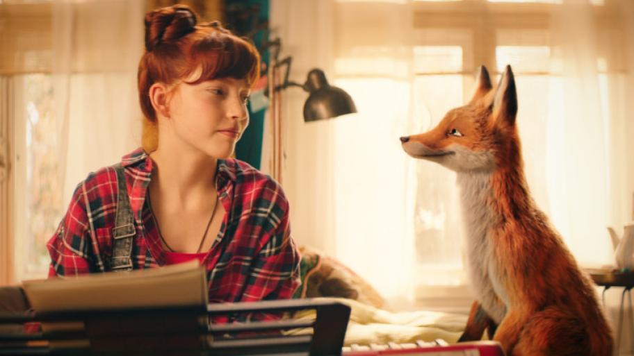 ein Mädchen und ein Fuchs sitzen am Schreibtisch und schauen sich an