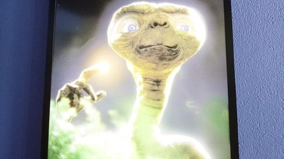 ein Bild von einem Alien mit weiß leuchtenden Augen und einem hell erleuchtetenden Finger ist zu sehen