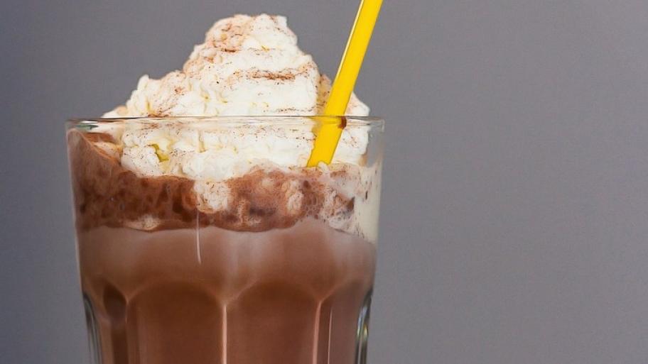 Eisschokolade mit Sahne, serviert in einem hohen Glas mit gelbem Strohhalm