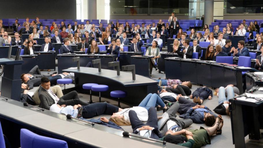 Jugendliche liegen im Plenarsaal des Bundestages auf dem Boden