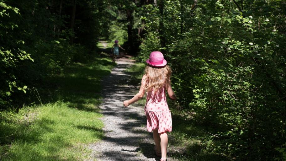 Kind läuft auf Waldweg