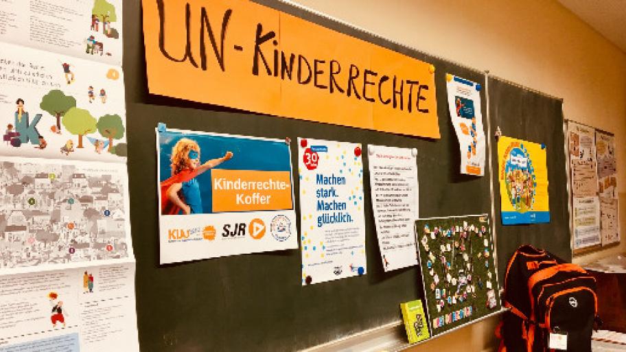 an einer großen Tafel in einem Klassenzimmer sind verschiedene Materialien, Plakate, Texte zum Thema Kinderrechte angeheftet