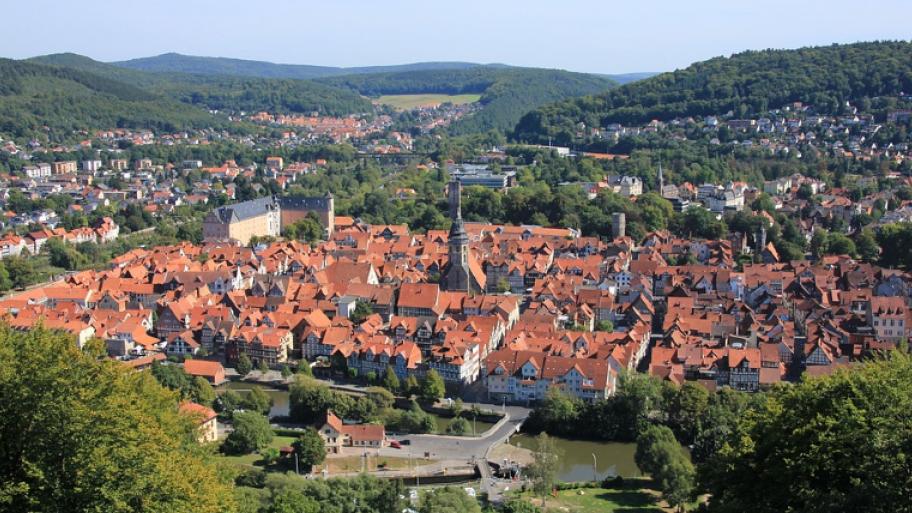 eine Kleinstadt wird von oben abgebildet. Man kann vor allem die roten Dächer sehen. Die Stadt befindet sich in einem Tal