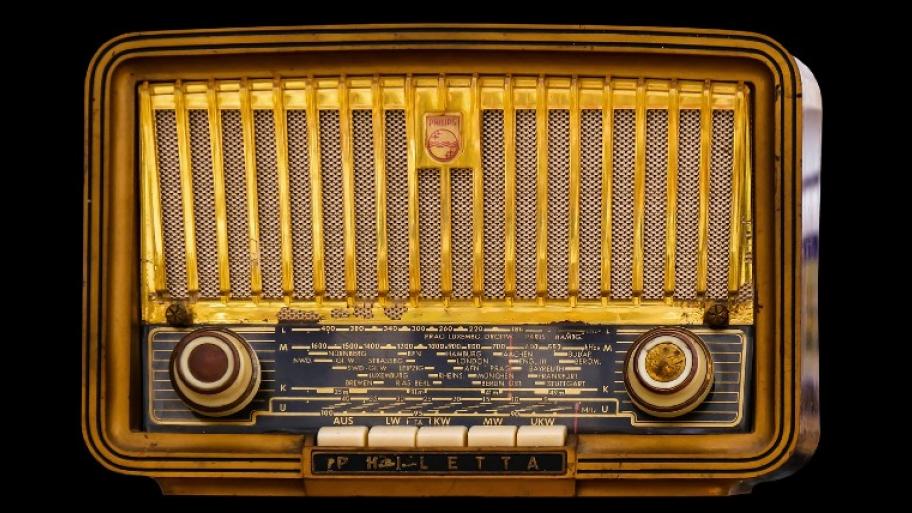 Altmodisches Radiogerät aus den Anfängen des Radios, gelb, Vorderansicht.