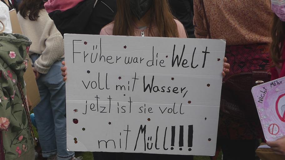 Ein Demonstrationsschild auf dem "Früher war die Welt voll mit Wasser, jetzt ist sie voll mit Müll!" steht