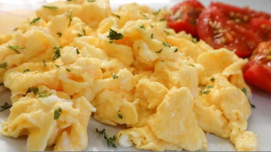 Rührei serviert mit Tomaten und Kräutern