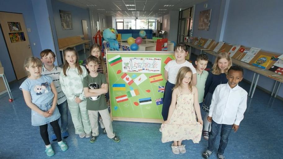 Schüler*innen der Franz-Leuninger-Schule in Mengerskirchen stehen auf dem Schulflur um ein Plakat, auf dem "Ländercafé" steht