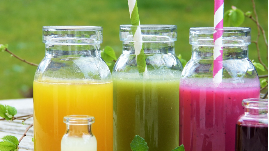 Zu sehen sind drei Gläser, die mit Smoothies gefüllt sind. Die Smoothies sind gelb, grün und lila. 
