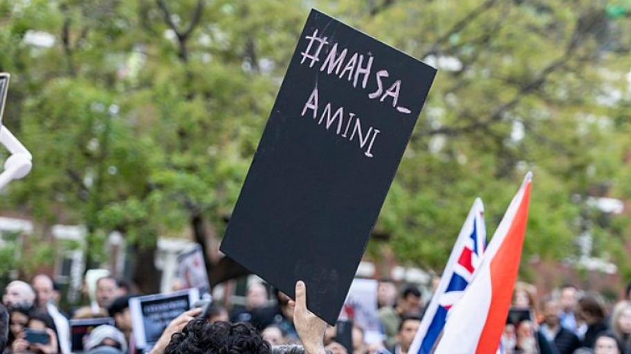 Menschen in  Melbourne (Australien) demonstrieren aus Solidarität für Mahsa Amini, Mensch hält Demoschild in die Luft mit Aufschrift "#Mahsa_Amini"