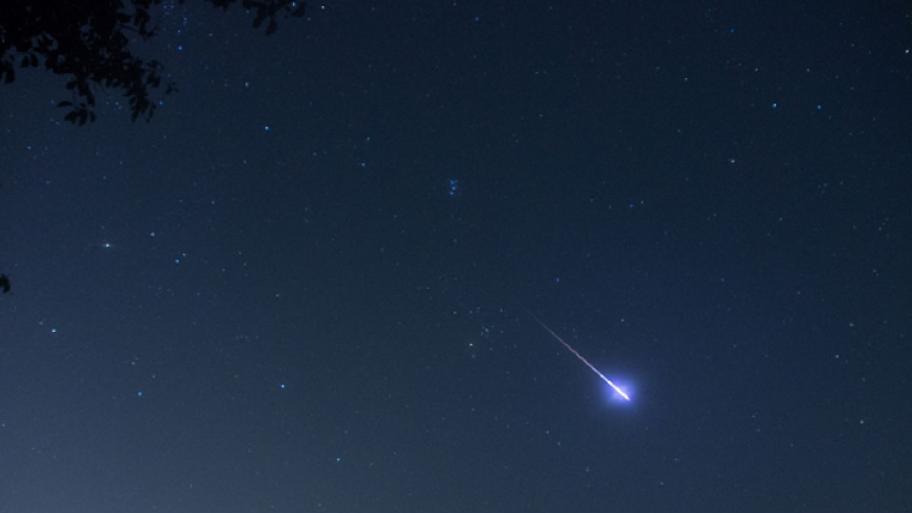 man kann eine Sternschnuppe am Nachthimmel erkennen