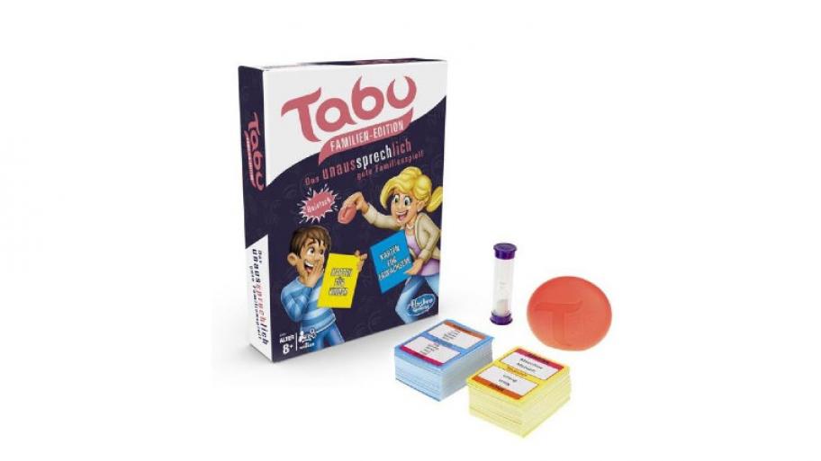 Spielkarton des Spiels "Tabu Familien-Edition", daneben steht eine Sanduhr, vor der sich die zwei Kartenstapel aus Kinder- und Erwachsenen-Karten befinden und die "Quietsche"