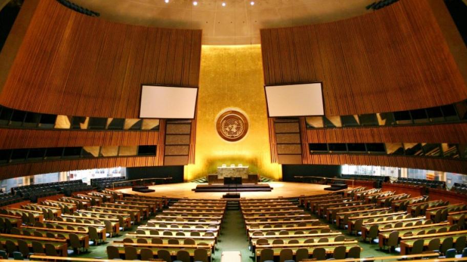 der Saal der Generalversammlung der Vereinten Nationen in New York, vorne ein großes Rednerpult, davor viele leer Stuhlreihen 