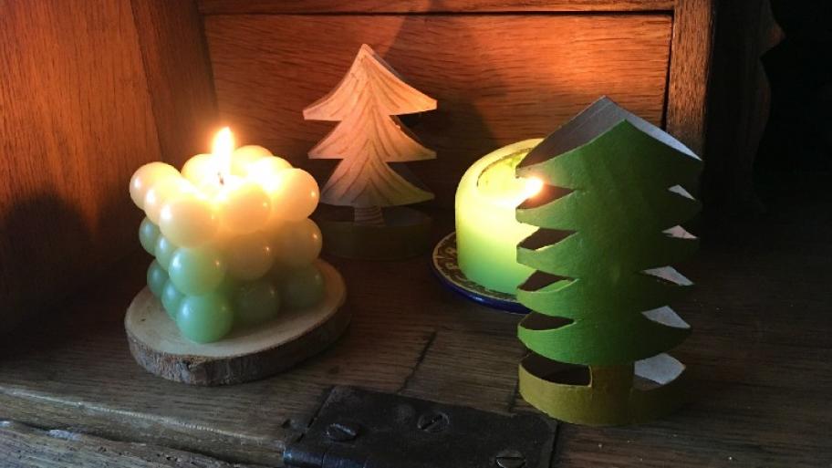 Weihnachtsbäume aus Klopapierrollen; es leuchten Kerzen