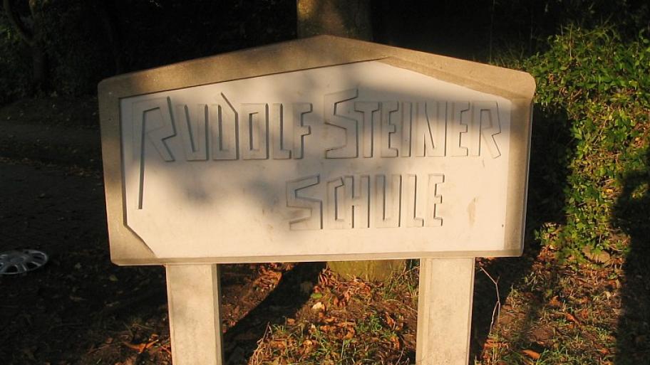 ein steinernes Schild mit der Aufschrift "Rudolf Steiner Schule" auf zwei steinernen Pfählen