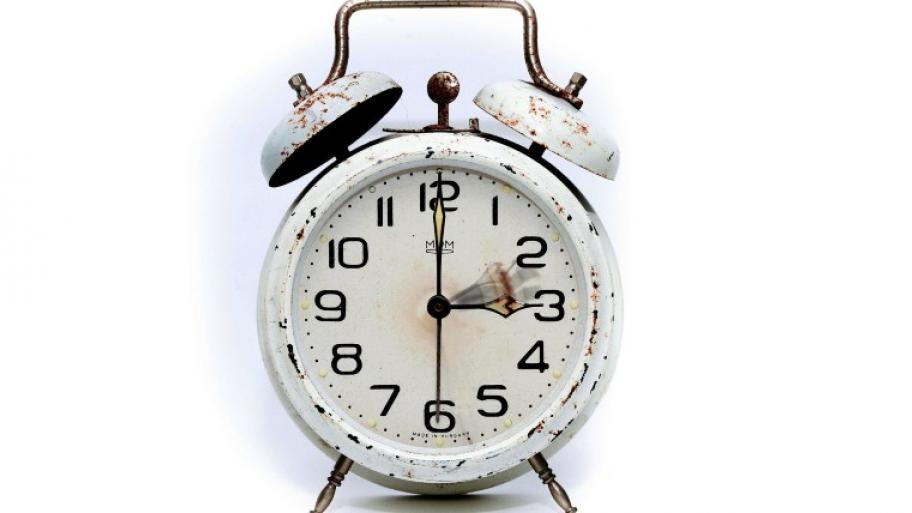ein alter, weißer Metallwecker zeigt 3 Uhr an