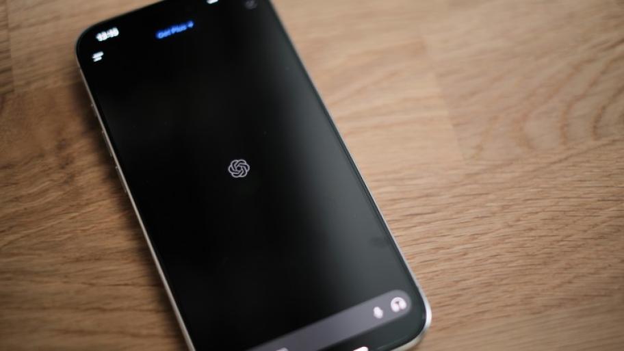 Ein Handy auf einem Holztisch. Auf dem Handy ist ChatGPT geöffnet.