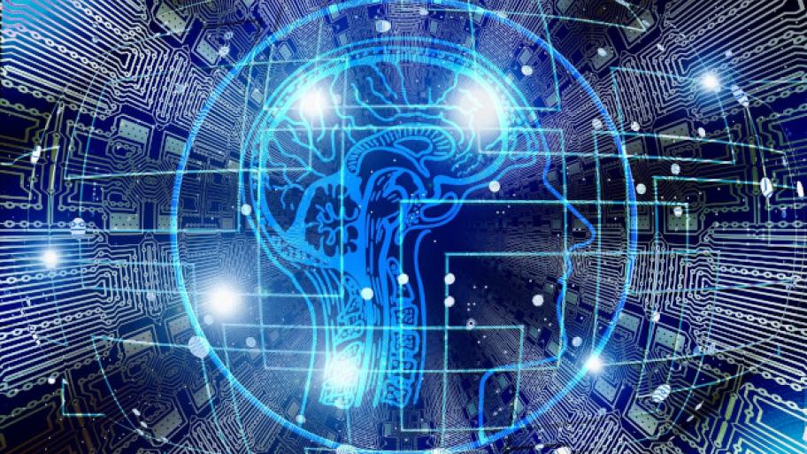 im dunkelblauen Hintergrund Computer-Platinen, darauf die Grafik eines menschlichen Kopfes mit Gehirn, drumherum unregelmäßige Gitterlinien und Lichtpunkte
