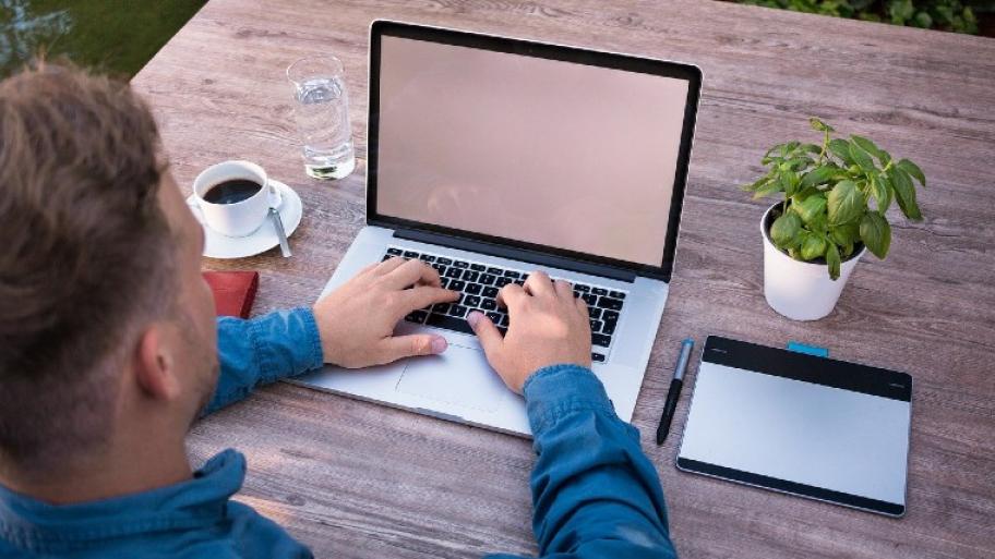 Mann sitzt am Laptop