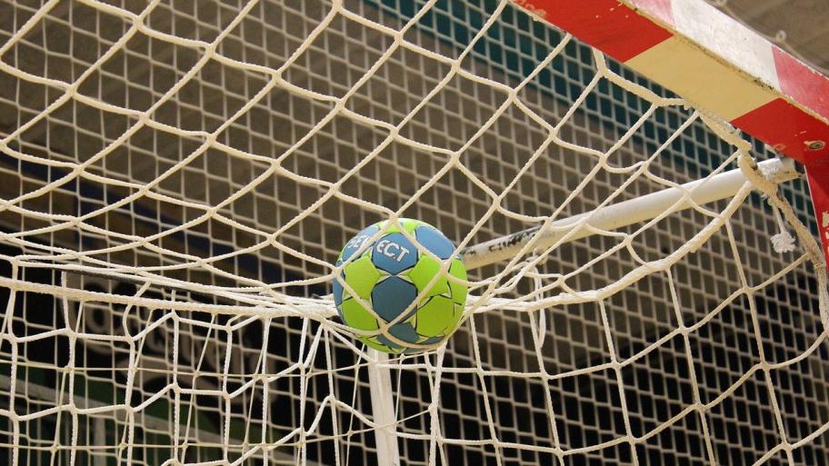 Handball liegt auf dem Tor im Netz