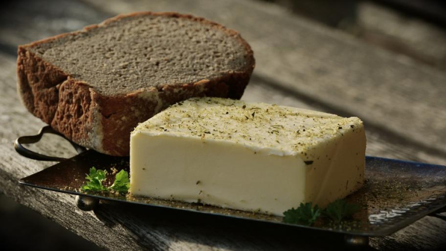 Butterblock auf Teller; daneben Brot kastenförmig, aufgeschnitten und halbiert