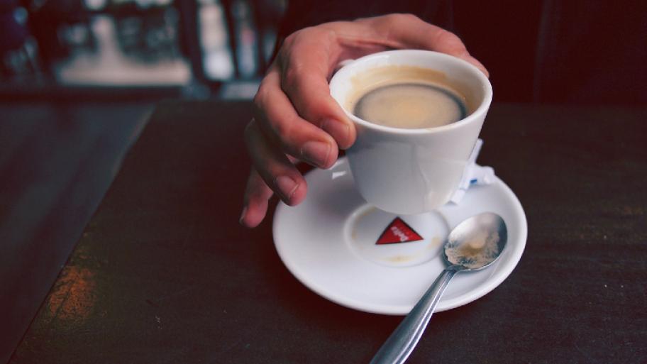 Eine Hand hält eine Tasse Kaffee