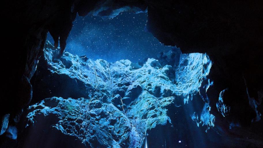 Höhle getaucht in blaues Licht; Blick aus der Höhle in den Sternenhimmel