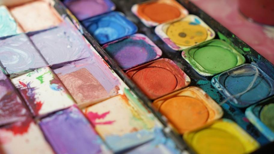 Tuschkasten mit lauter Farben: rot, lila, blau, grün, gelb, orange.