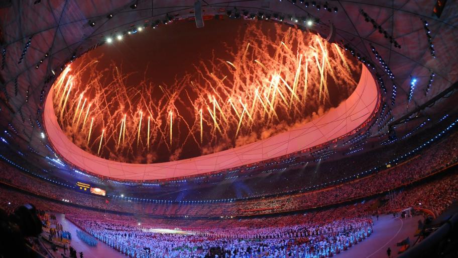 Olympische Spiele im Stadion mit einem großen Feuerwerk und vielen Menschen auf den Tribünen und dem Spielfeld