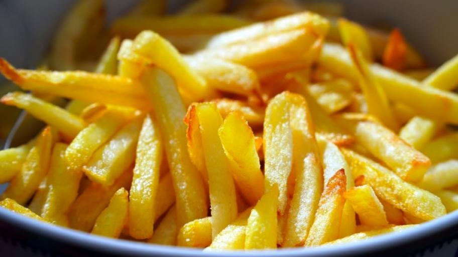 eine weißen Porzellanschüssel gefüllt mit knusprigen Pommes frites