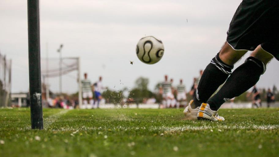 Auf dem Fußballfeld wird ein Fußball geschossen